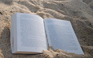 Uppslagen bok på en strand