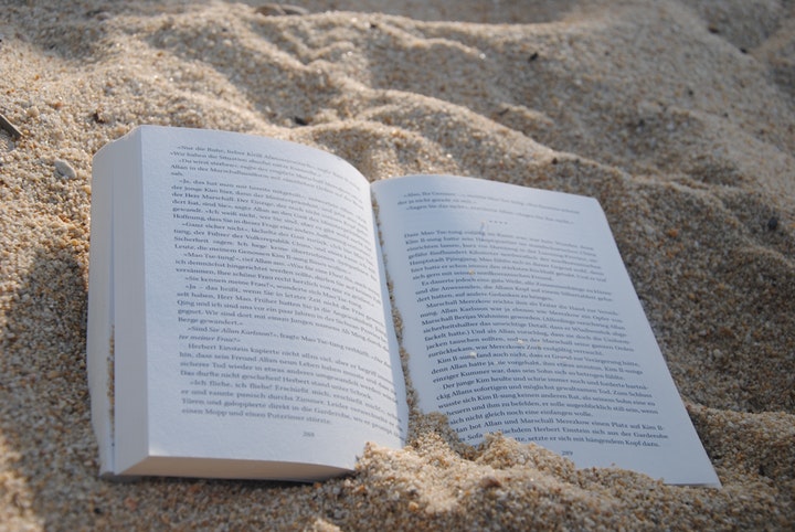 Uppslagen bok på en strand
